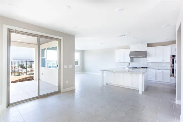 a large white kitchen with white cabinets and a refrigerator