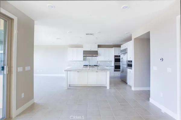 a large white kitchen with cabinets