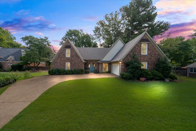 a front view of a house with yard and green space