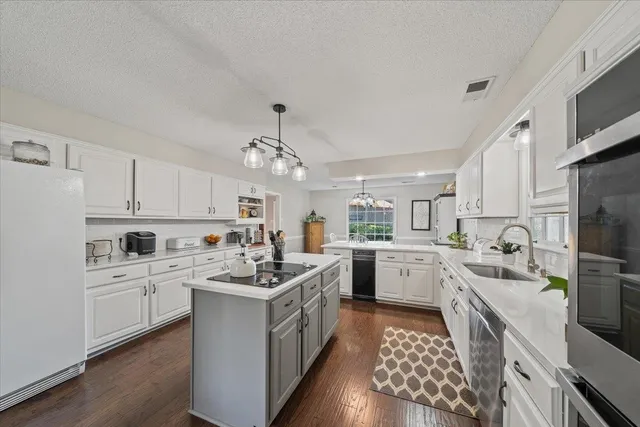 a kitchen with a sink stove cabinets and refrigerator