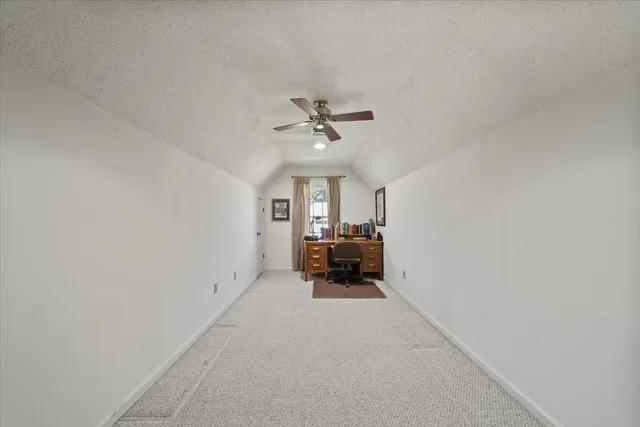 an empty room with furniture and a ceiling fan