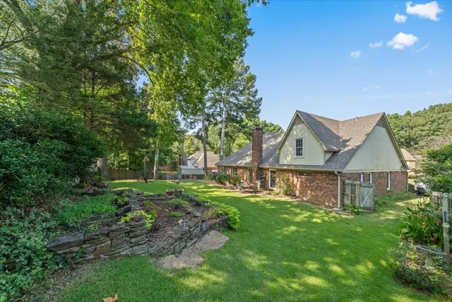 a view of a house with backyard and a tree