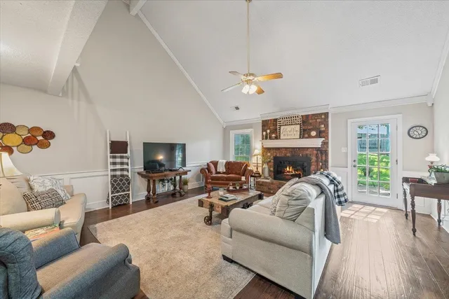 a living room with furniture a fireplace and a flat screen tv