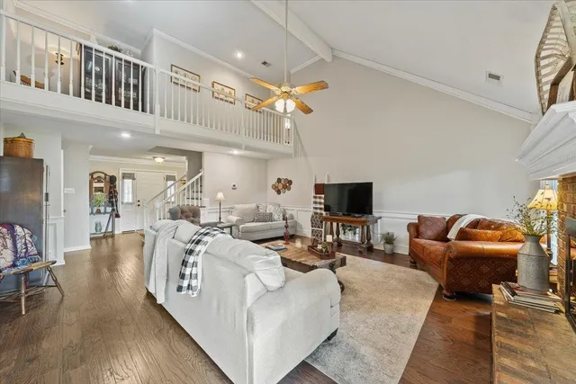 a living room with furniture a flat screen tv and a table