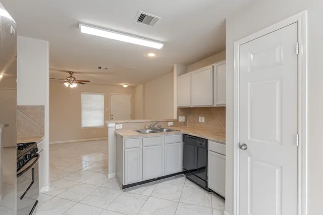 a kitchen with a sink window and cabinets