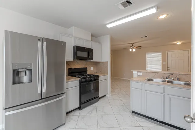 a kitchen with a sink stainless steel appliances and cabinets