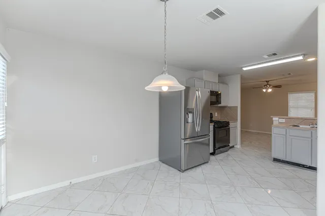 a kitchen with refrigerator and cabinets