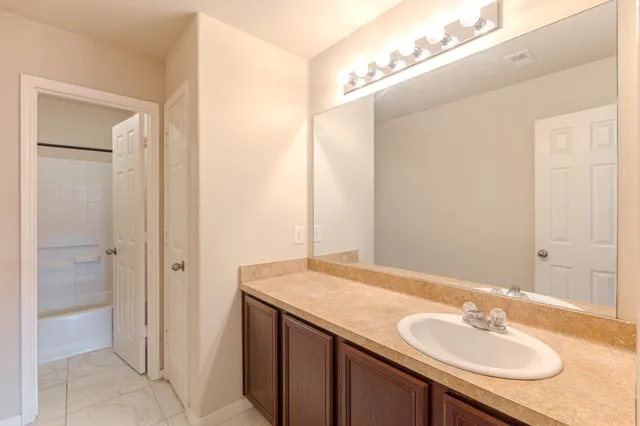 a bathroom with a granite countertop sink and a mirror