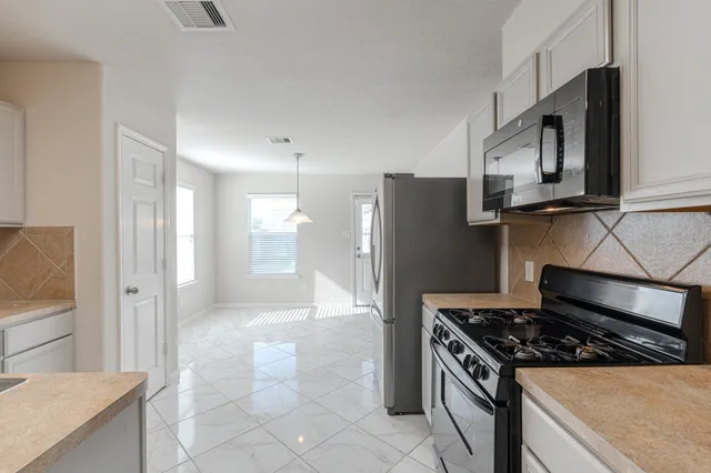 a kitchen with stainless steel appliances granite countertop a refrigerator and a stove