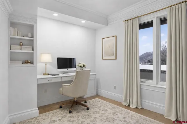 a view of a workspace with furniture and a window