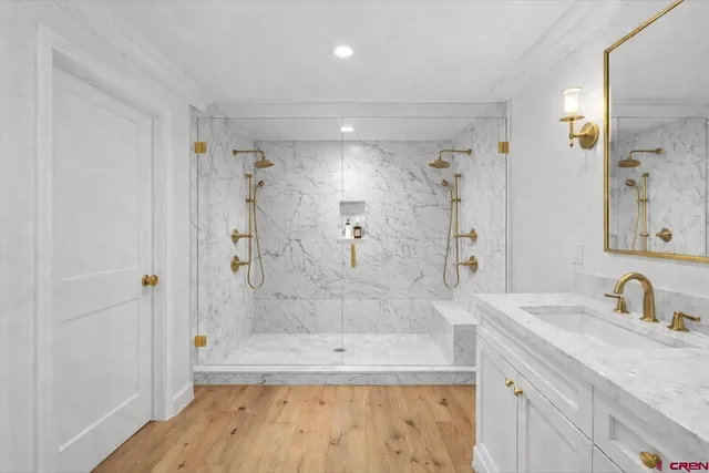 a bathroom with a granite countertop sink a mirror a bathtub and shower