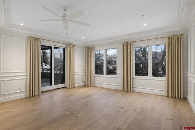 a view of a livingroom with a chandelier fan and windows