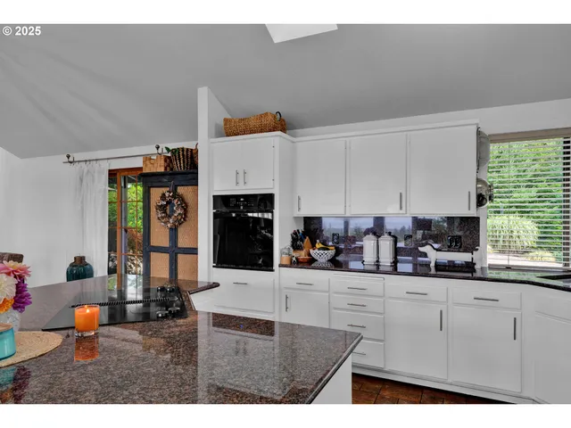 a kitchen with stainless steel appliances a stove a sink and white cabinets