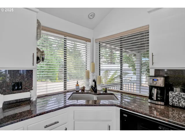 a kitchen with granite countertop a sink and a window