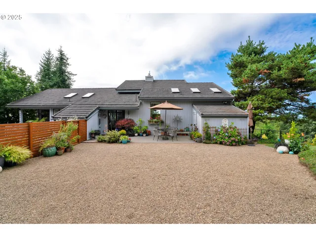 a front view of a house with a garden and mountain view