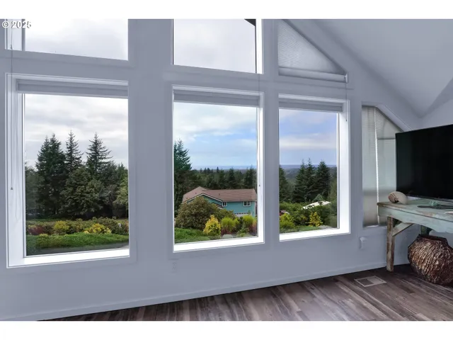 a living room with a large window and a flat screen tv