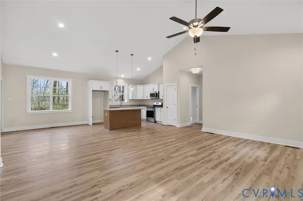 a view of kitchen with stove and white cabinets with wooden floor