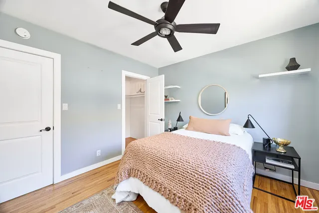 a bedroom with a bed and wooden floor