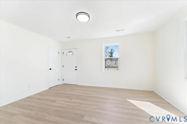 a view of a room with wooden floor and window