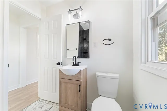 a bathroom with a toilet a sink and mirror