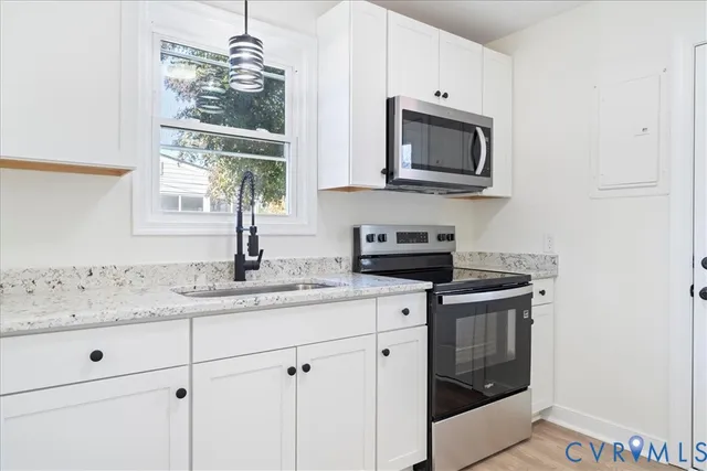 a kitchen with stainless steel appliances granite countertop a sink and a microwave
