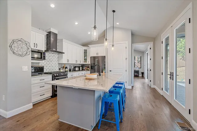 a large kitchen with cabinets wooden floor and stainless steel appliances