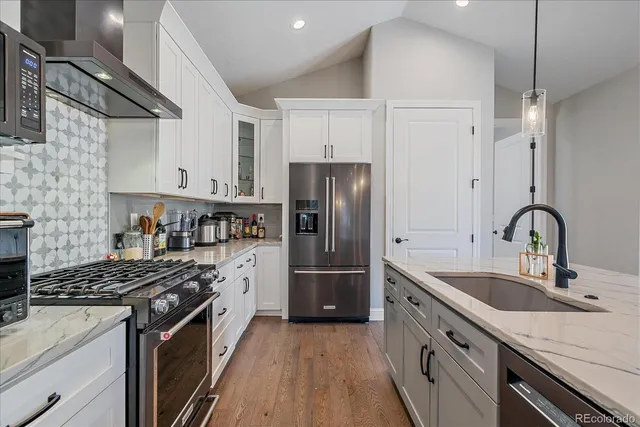 a kitchen with stainless steel appliances granite countertop a sink stove and refrigerator