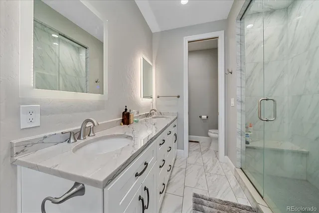 a bathroom with a sink a toilet and shower