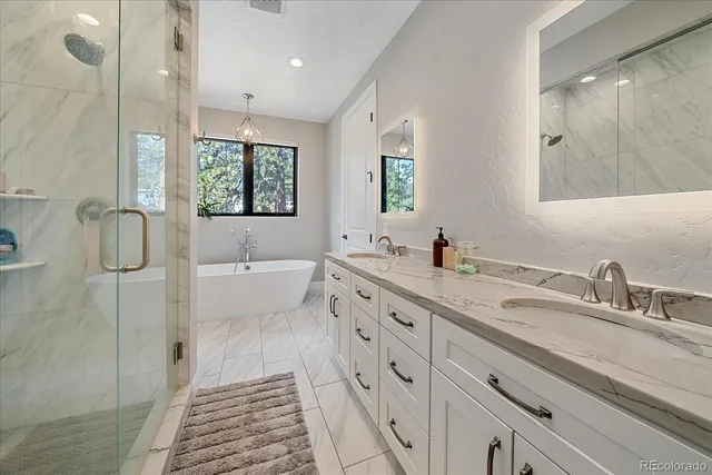 a spacious bathroom with double vanity sink a mirror and a shower
