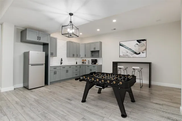 a kitchen with stainless steel appliances kitchen island granite countertop a refrigerator a stove a sink dishwasher and white cabinets with wooden floor