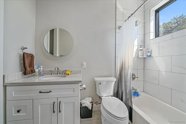 a bathroom with a toilet a sink a vanity and mirror