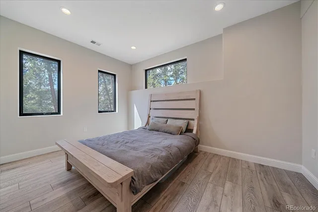 a bedroom with a bed and wooden floor