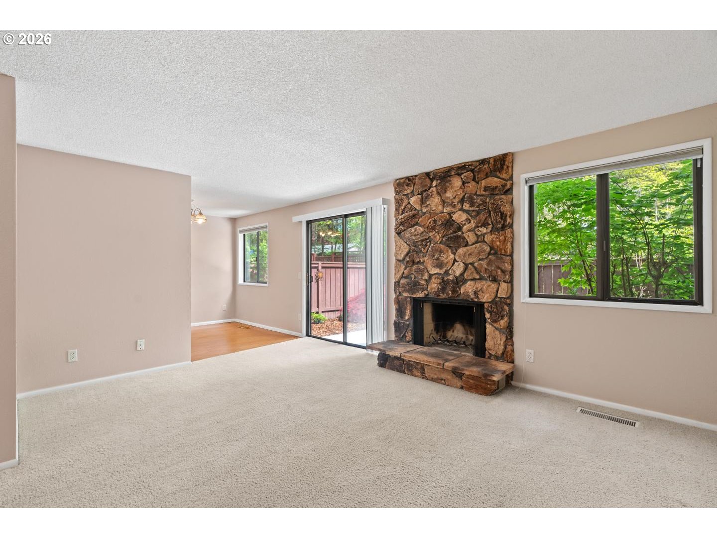 5792 Southwest 204th Place Beaverton, OR 97078 - Photo 6 of 33 a view of an empty room with a fireplace and a window