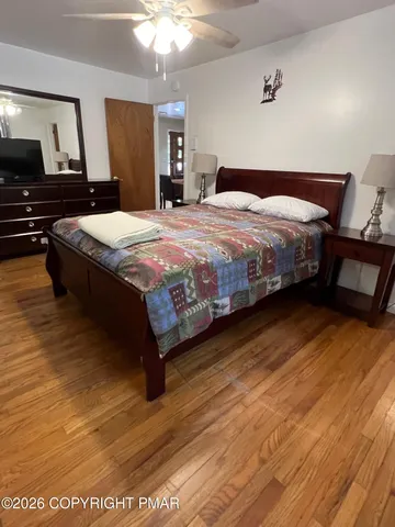 a bedroom with a bed and wooden floor