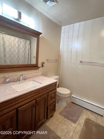 a bathroom with a granite countertop sink toilet and mirror