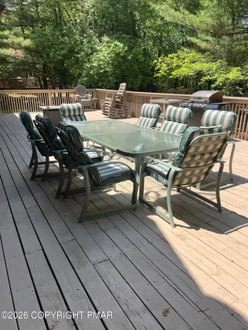 a roof deck view with table and chairs and wooden floor