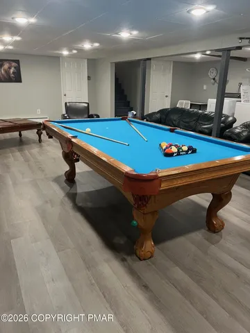 a room with pool table and windows