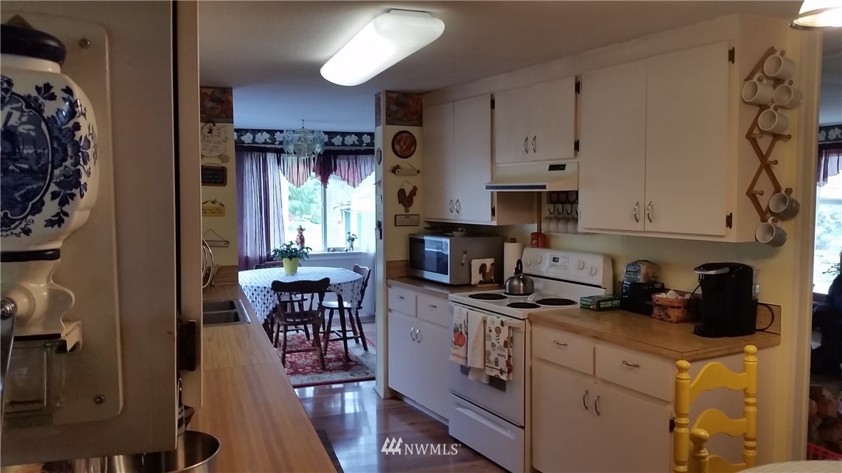 224 Wirta Road Winlock, WA 98596 - Photo 4 of 22 a kitchen with stainless steel appliances granite countertop a stove a sink a refrigerator and a dining table with wooden floor