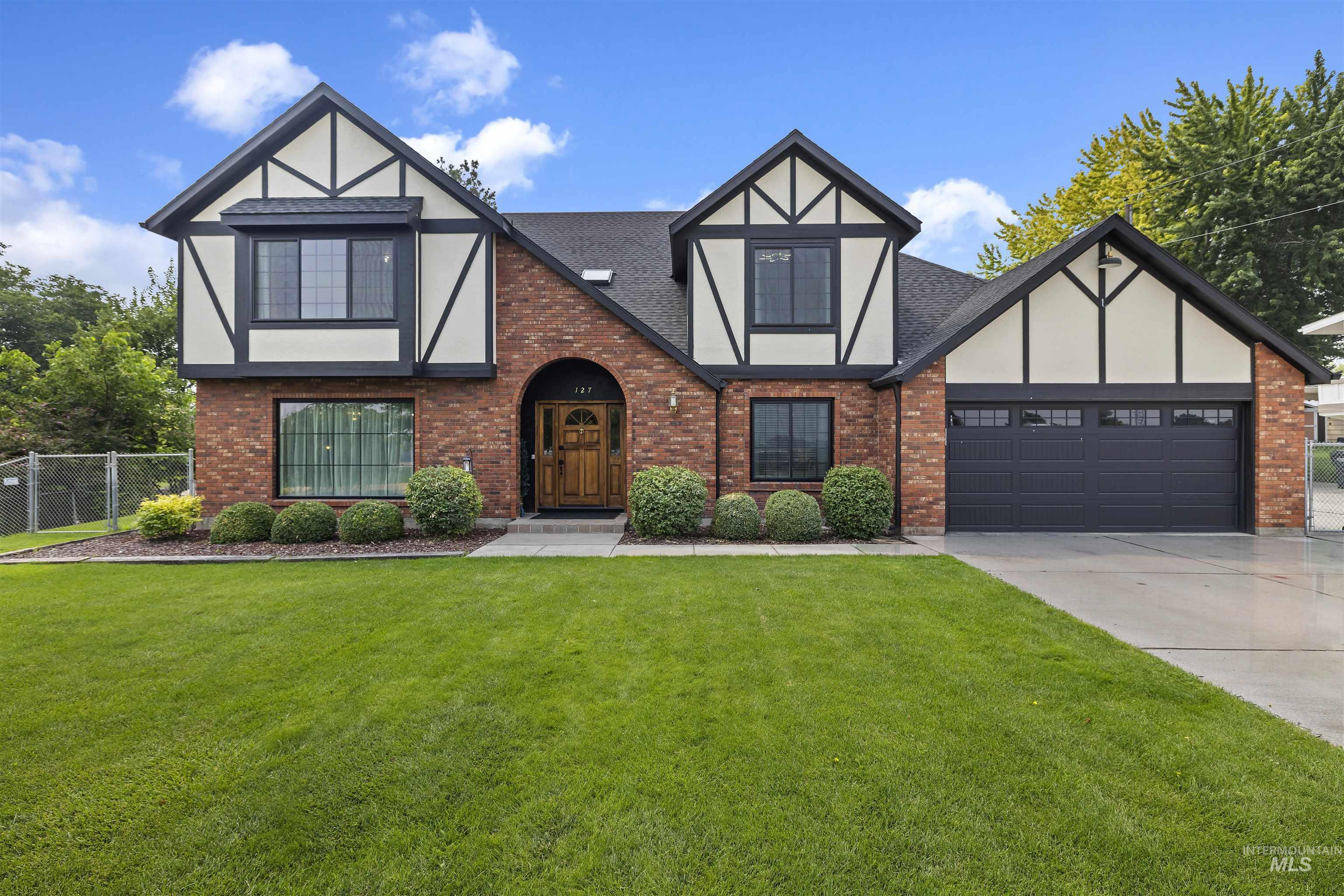 127 Ruth Lane Nampa, ID 83686 - Photo 2 of 49 Brick exterior featuring a wood-paneled arched doorway
