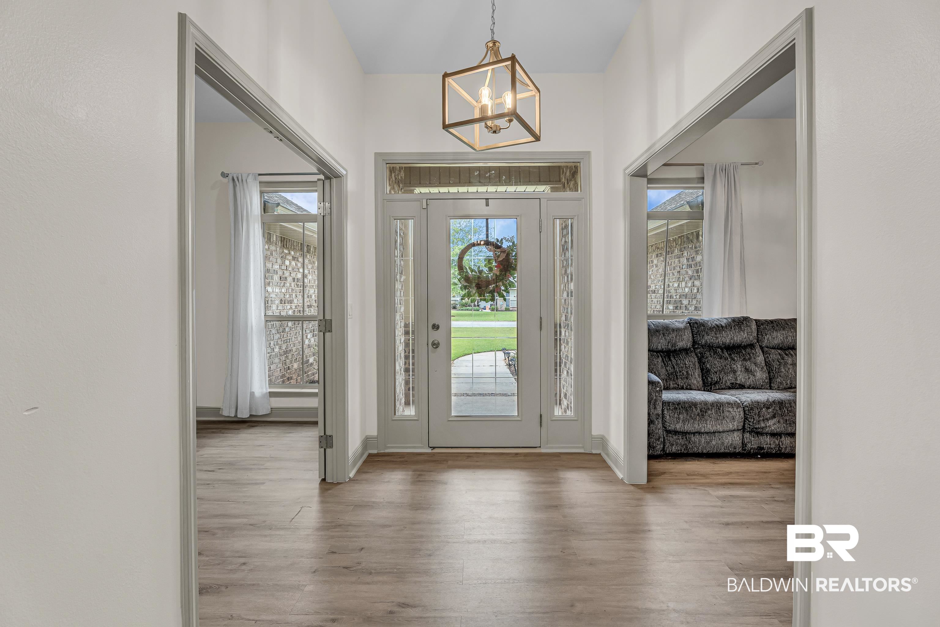 242 Meadow Run Loop East Foley, AL 36535 - Photo 3 of 52 Entryway with a chandelier and wood finished floors