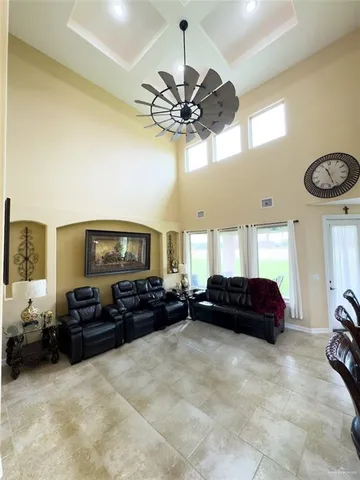 a living room with furniture a ceiling fan and a large window