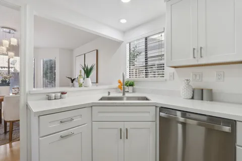 a kitchen with white cabinets and appliances