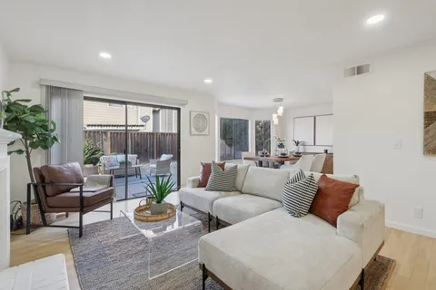 a living room with furniture a table and kitchen view