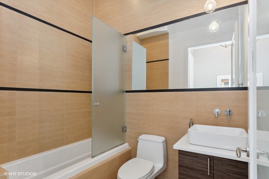 2408 West Rice Street, Unit 403 Chicago, IL 60622 - Photo 16 of 19 a bathroom with a toilet a sink and mirror