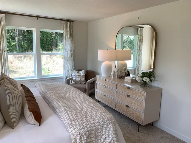 a bed room with a bed window and mirror