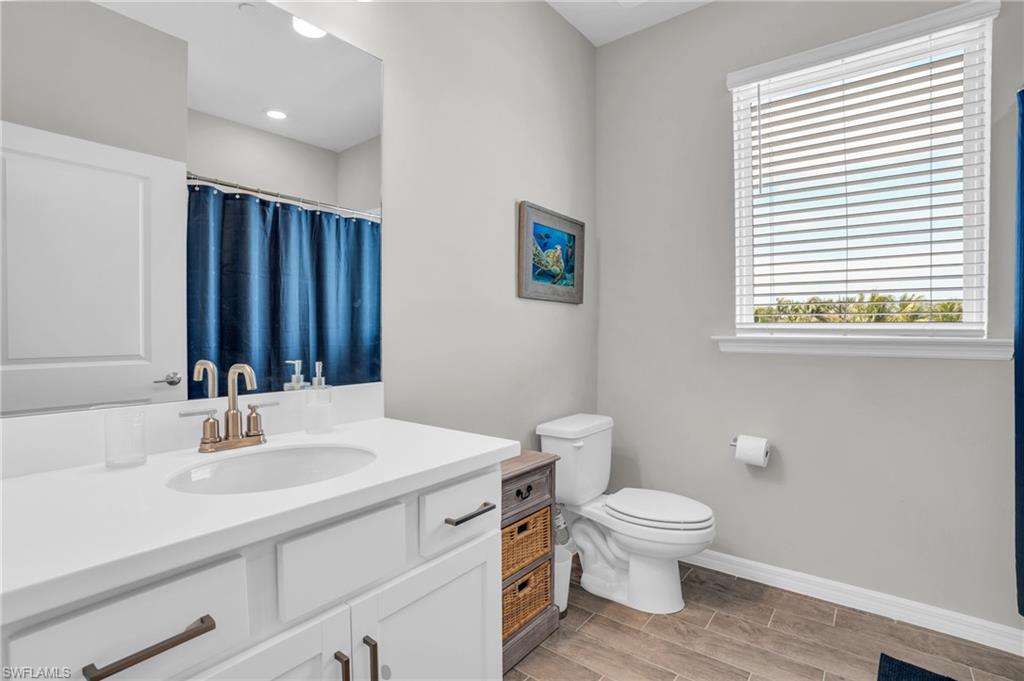 11761 Venetian Lagoon Drive, Unit 204 Fort Myers, FL 33913 - Photo 14 of 46 Bathroom featuring curtained shower, baseboards, toilet, and vanity