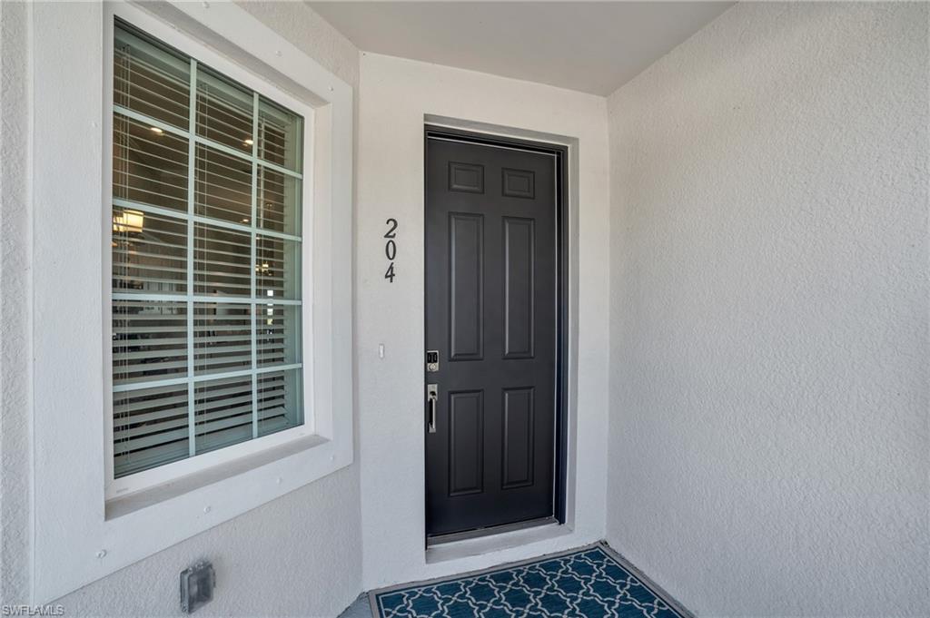 11761 Venetian Lagoon Drive, Unit 204 Fort Myers, FL 33913 - Photo 23 of 46 Doorway to property featuring stucco siding