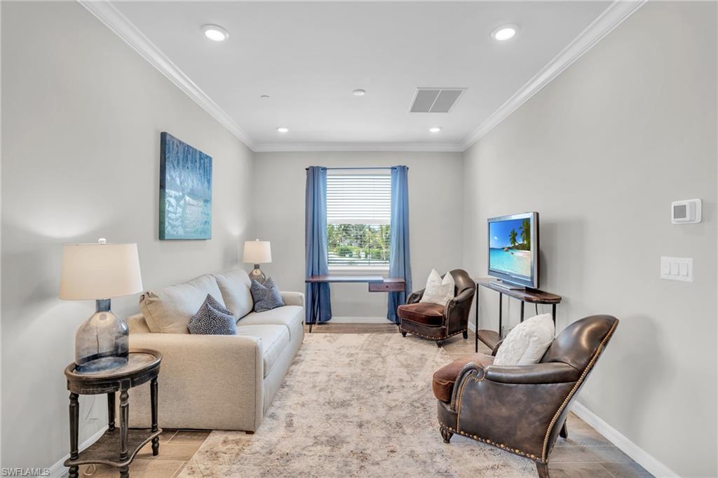 11761 Venetian Lagoon Drive, Unit 204 Fort Myers, FL 33913 - Photo 6 of 46 Living area featuring visible vents, baseboards, and ornamental molding