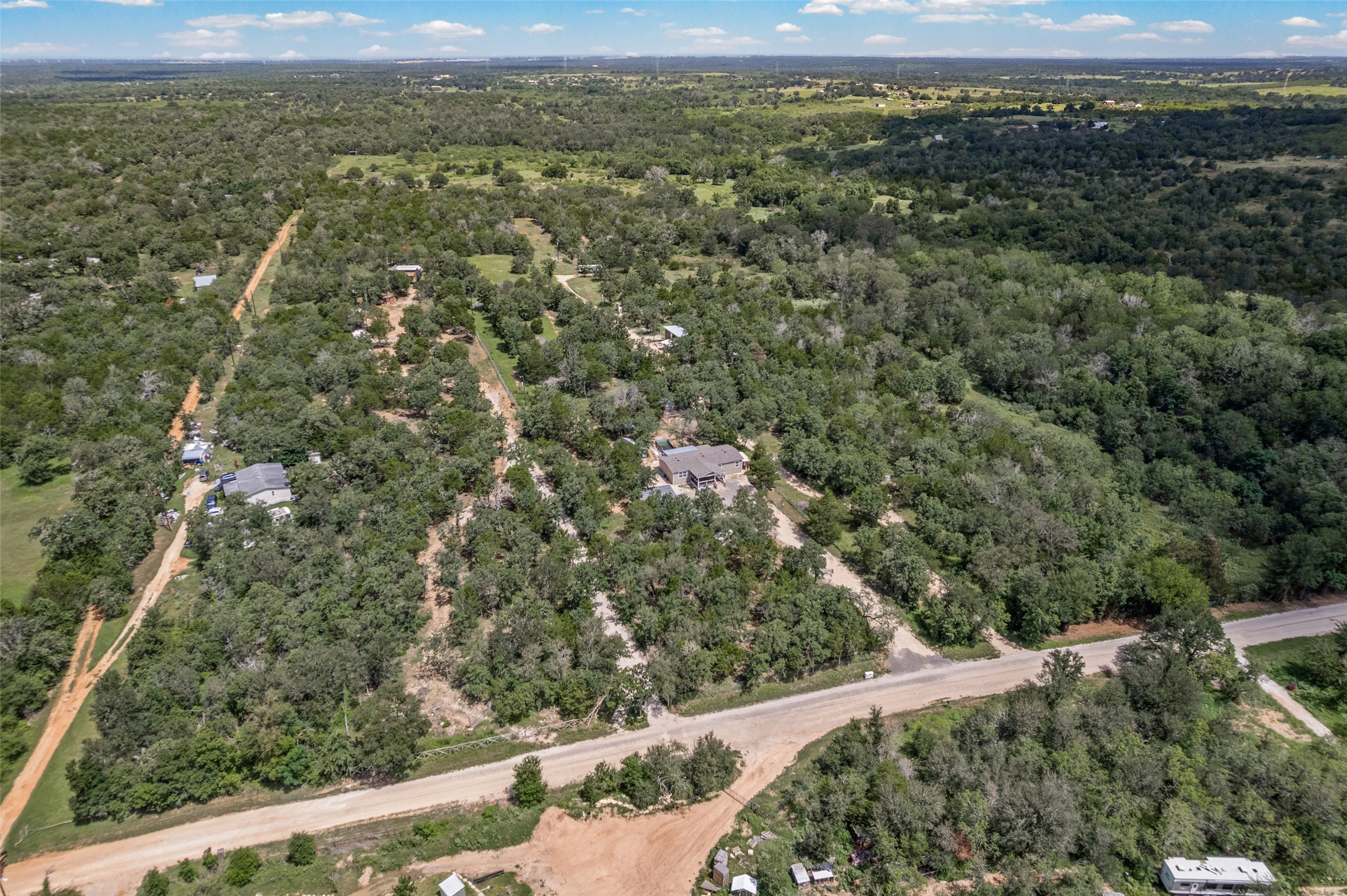 564 Boyd Road Red Rock, TX 78662 - Photo 3 of 25 Vast, verdant landscape surrounds a private residence with ample space for seclusion.