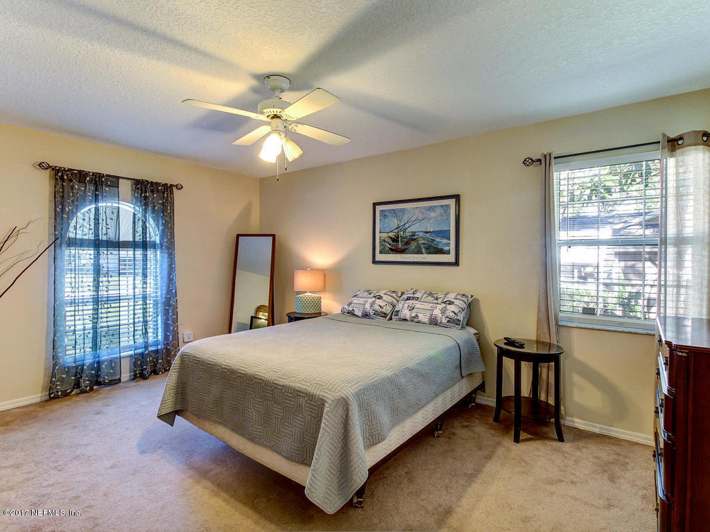 144 Tanager Road St. Augustine, FL 32086 - Photo 15 of 46 a bedroom with a bed and a chandelier